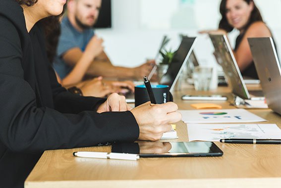 Woman taking notes during a team meeting